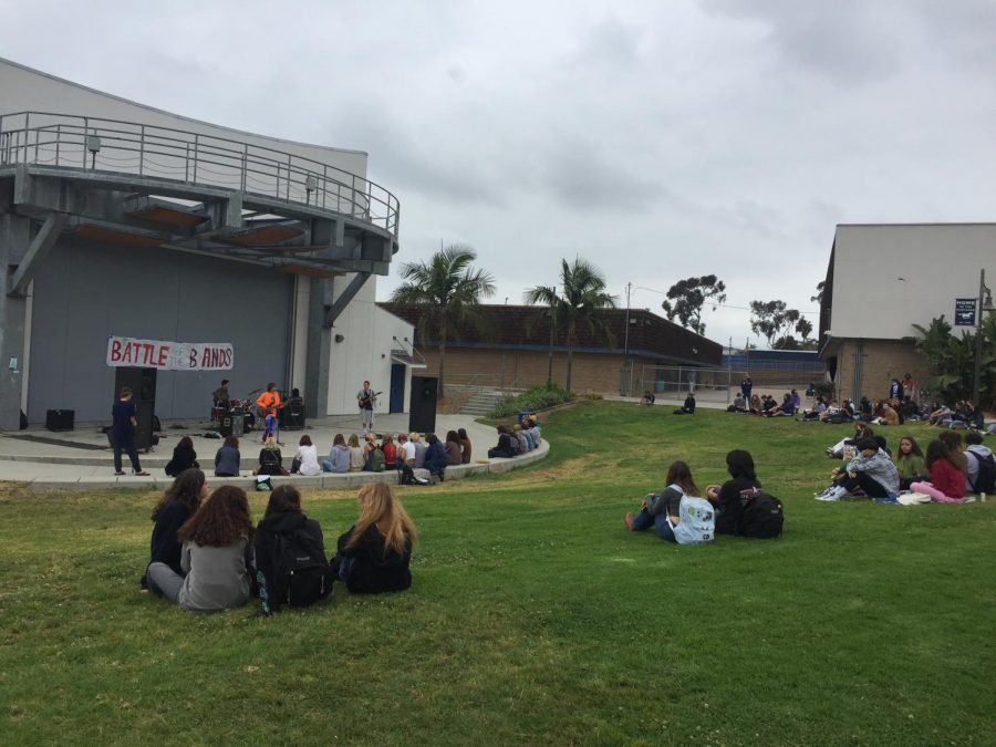students sitting on the grass while watching in the pac